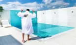 Cum arată curtea casei lui Dorian Popa la începutul primăverii. Nu are nici gazon, nici flori, ci pietre albe decorative și palmieri lângă piscină