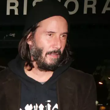 Keanu Reeves, zâmbitor alături de o blondă misterioasă