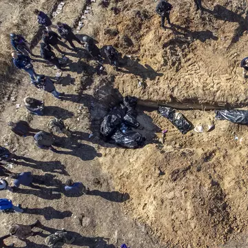 Foto / Un militar ucrainean a izbucnit în lacrimi în fața unei gropi comune cu civili uciși de ruși