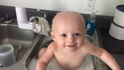 Explicația tristă din spatele imaginii. Un bebeluș spălat în chiuveta unei secții de poliție | FOTO