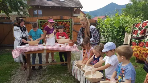 O profesoară îi învață pe turiști secretele savuroasei pâini tradiționale cu slănină