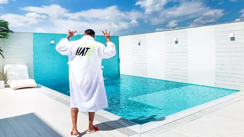 Cum arată curtea casei lui Dorian Popa la începutul primăverii. Nu are nici gazon, nici flori, ci pietre albe decorative și palmieri lângă piscină