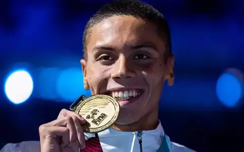 David Popovici, campionul mondial modest, care merge cu metroul. A fost fotografiat într-o stație din București, cu o domnișoară și câinele lui