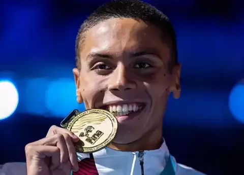 David Popovici, campionul mondial modest, care merge cu metroul. A fost fotografiat într-o stație din București, cu o domnișoară și câinele lui