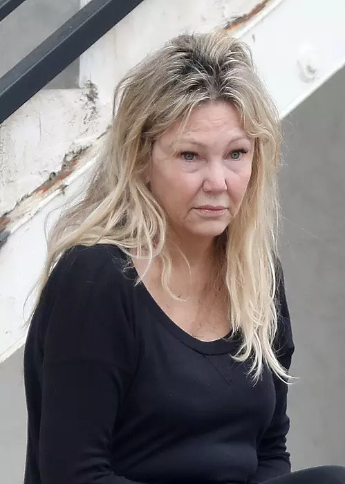 Heather Locklear looks lost in thought and somewhat disheveled whilst sitting on a curb waiting for a ride home in the scorching LA heat.