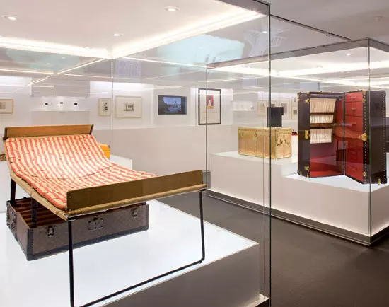 Daca in toate spatiile expozitiei comorile Louis Vuitton erau asezate ordonat si puse in valoare doar de fotografii emblematice din arhivele casei, in ultima incapere se intimpla ceva complet diferit. Lasata aproape in intregime goala, camera era mobilata de cufarul-pat pliant, cufarul-dulap si cufarul-birou, toate desfacute si aranjate astfel incit sa inchipuie un dormitor obisnuit. Mici filme cu personaje din alte timpuri erau proiectate pe fiecare cufar si faceau acel spatiu si mai veridic. Trebuie sa recunosc ca, daca as putea sa aleg unul dintre modelele expozitiei, as alege cufarul-dulap, care mi s-a parut foarte sexy cu sertarele desfacute neglijent si imaginea retro a unei femei proiectata in interiorul acestuia.  