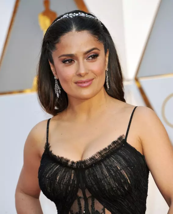 Salma Hayek. Rochia misterioasă și sexy Alexander McQueen a actriței a mers la fix cu un make-up în tonuri de ametist, gene voluminoase, sprâncene conturate, ruj rose-nude, pomeți evidențiați cu fard iluminator și bucle extrem de lejere.