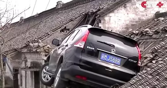 E o pasăre, e un avion! Nu! E o Honda pe o casă! Vezi cum a ajuns un SUV pe acoperișul unui imobil! | VIDEO