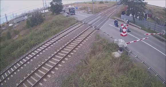 Video: Ce pățește un motociclist care trece printre bariere la calea ferată