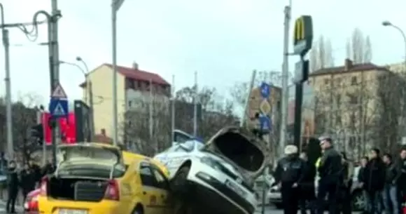Accident spectaculos în Capitală. Mașină de poliție cocoțată peste un taxi