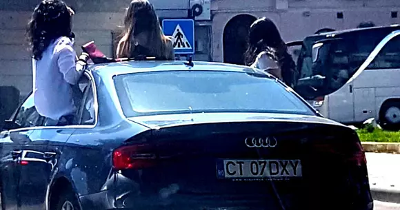 Fete filmate în trafic pe jumătate ieșite din mașină, amendate de polițiști (Video)