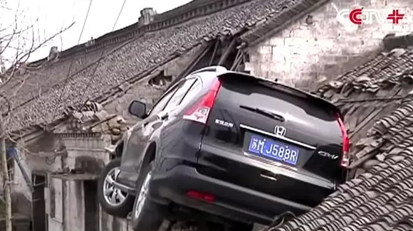 E o pasăre, e un avion! Nu! E o Honda pe o casă! Vezi cum a ajuns un SUV pe acoperișul unui imobil! | VIDEO