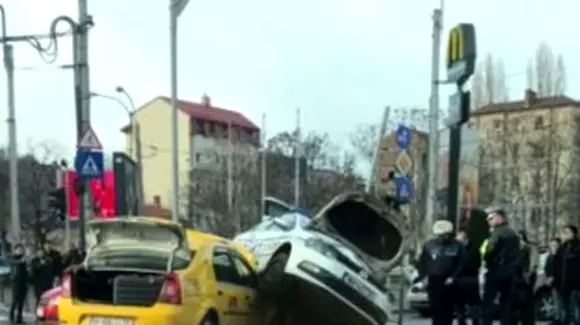 Accident spectaculos în Capitală. Mașină de poliție cocoțată peste un taxi