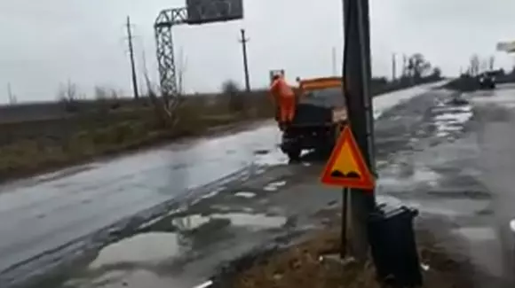 Un muncitor a fost filmat în timp ce turna asfalt fierbinte direct în gropile pline cu apă