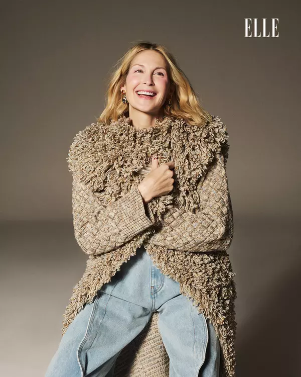 Kelly poartă pulover „Clouded Squares“ și vestă lungă „Knitted Fur“ din lână merinos multicoloră, Ami Amalia; jeanși Y/Project și cercei The Collector, magazinul Aparterre.