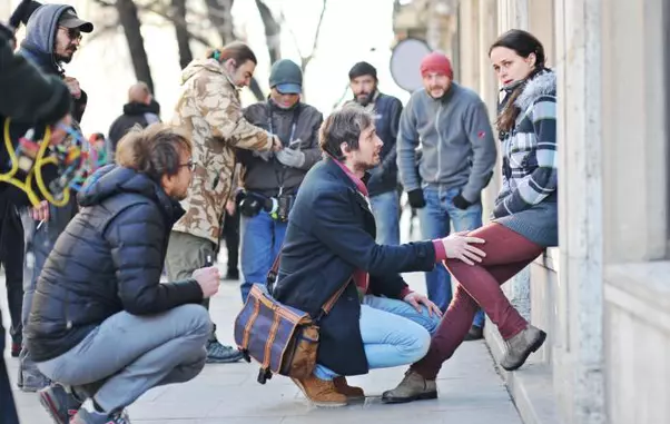 Călin Peter Netzer surprins în timp ce le dădea indicații actorilor Mircea Postelnicu și Diana Cavallioti pentru o scenă filmată în fața Universității