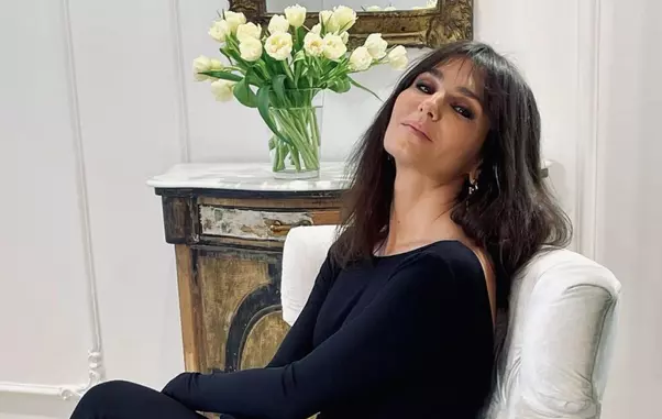 dana-budeanu-sta-pe-un-fotoliu-alb