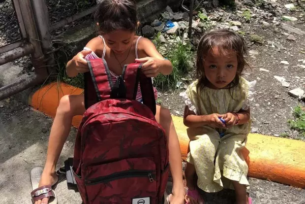 Fetita de 8 ani, nevoita sa-si faca temele pe strada, in ploaie 2