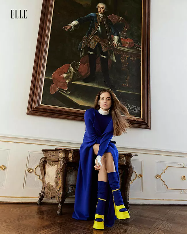 Cleo poartă capă, maletă și șosete, toate Ami Amalia, și pantofi, Versace.