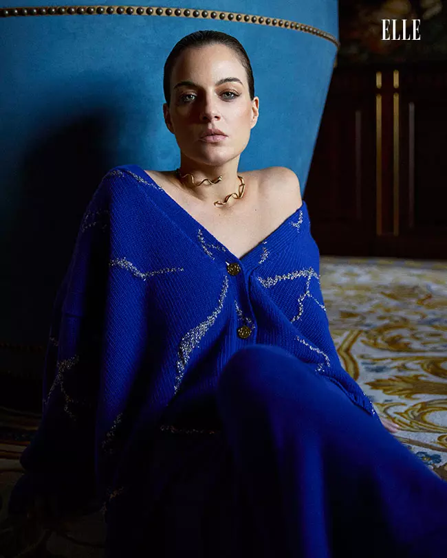 Cleo poartă cardigan "Gilded Perfections" și fustă, ambele Ami Amalia, și colier Ole Lynggaard Copenhagen.