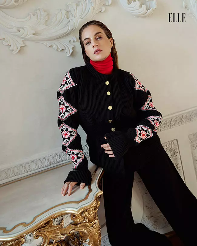 Cleo poartă cardigan "Romanian Blouse", maletă și pantaloni, toate Ami Amalia. 