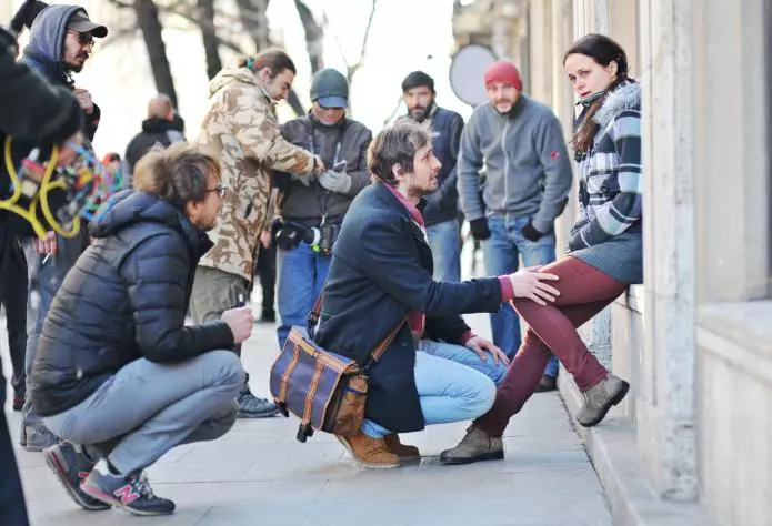 Călin Peter Netzer surprins în timp ce le dădea indicații actorilor Mircea Postelnicu și Diana Cavallioti pentru o scenă filmată în fața Universității