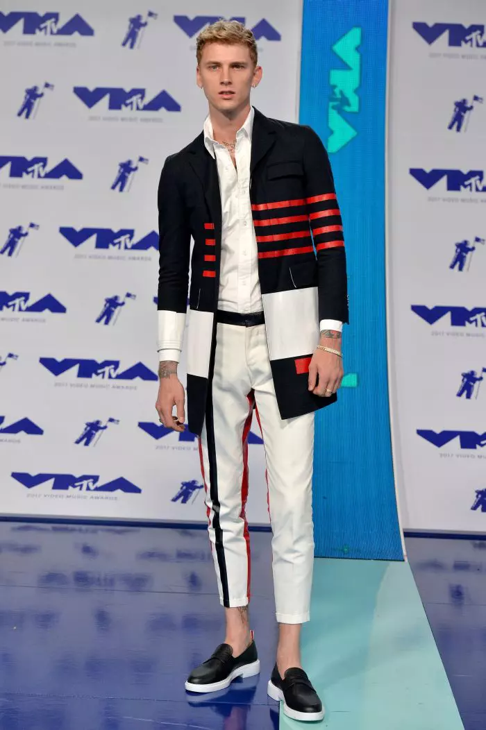 Rapper-ul Machine Gun Kelly arată ca un gentleman într-un costum alb-negru cu accente roșii.