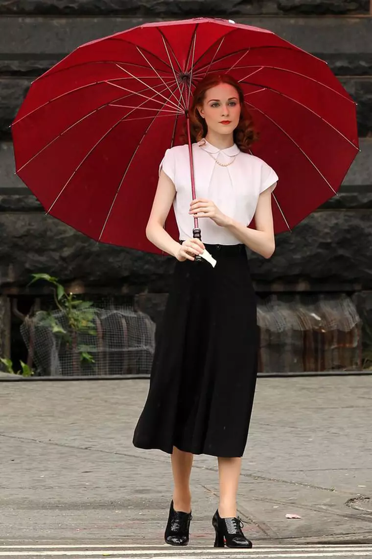 EXCLUSIVE: Actress Evan Rachel Wood, dressed in black knee-length skirt and white blouse, walks to her trailer with an umbrella on the set of her latest movie Mildred Pierce filming in Harlem in New York City, New York on June 1, 2010.