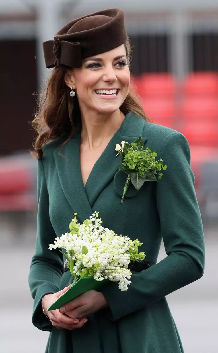 ALDERSHOT, ENGLAND - MARCH 17:  Catherine, Duchess of Cambridge celebrates St Patrick's Day by handing out Shamrocks to the Irish Guards in Aldershot, England, March 17, 2012. Dichess arrived at Mons Barracks in Aldershot to present Irish Guard soldiers with shamrocks to mark St. Patrick's Day.  During the presentation, Kate Middleton also pinned shamrocks to the collar of a very special member of the regiment:  their mascot, an Irish Wolfhound dog named Conmeal. This was the first solo military engagement for Kate, who smiled all through the event.  You may recall that Prince William was appointed the honorary rank of Colonel of the Irish Guard last  year, and the newlyweds presented medals to members of the regiment in june on Armed Forces Day. Duchess wore a green coat dress and black belt by designer Emilia Wickstead.  Kate's shoes are somewhat of a mystery to us. The brown suede heels are new, at least to the public, and believed to be Emmy Shoes. (Photo by Chris Jackson/WPA Pool/Photoshot/iPhoto)