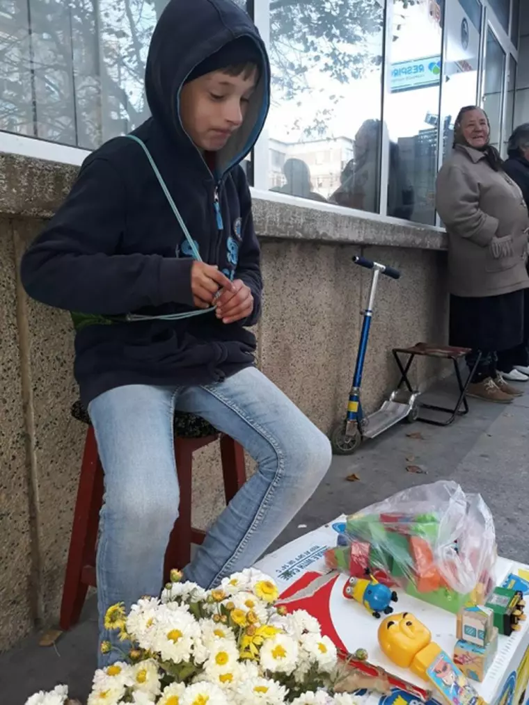 Un copil de 10 ani își vinde jucăriile pe o stradă din Mioveni
