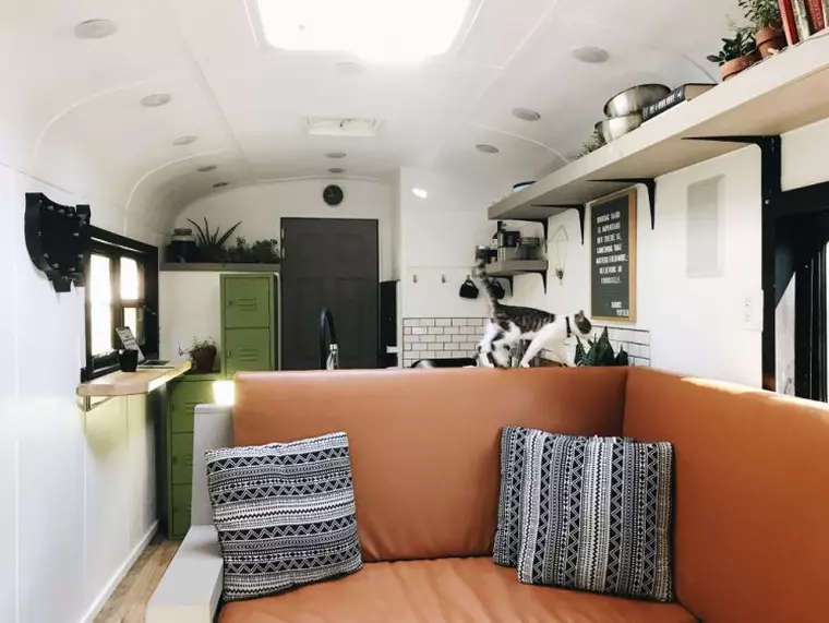 Cum arată familia care trăiește într-un autobuz școlar - interiorul autobuzului amenajat modern, o canapea si mobilier alb