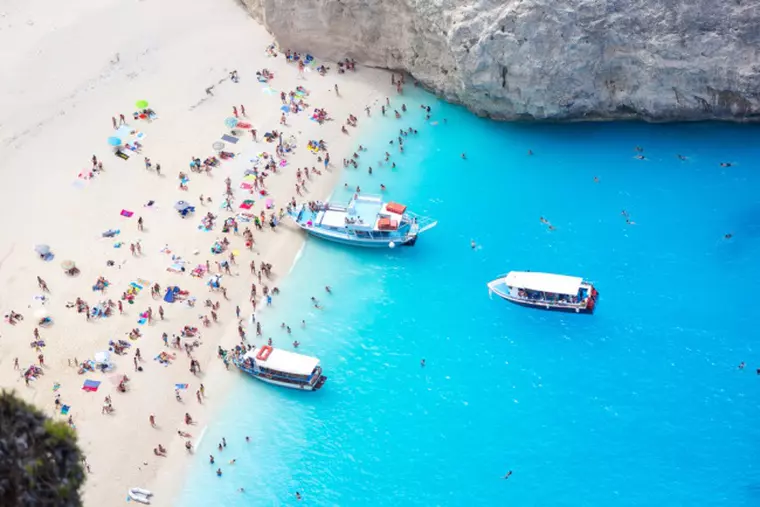 Navagio beach of people and three reantal boats, Shipwreck bay, Zakynthos island, Greece.
