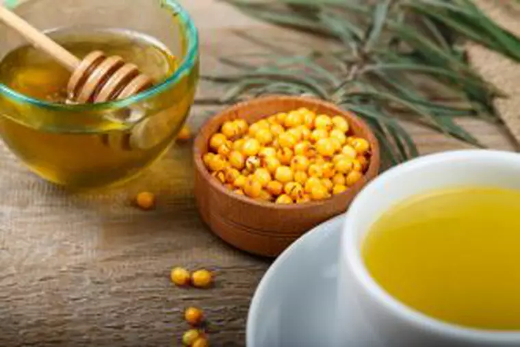 Cătină cu miere- Bol cu miere, alături de un bol cu cătina si o cească de sirop