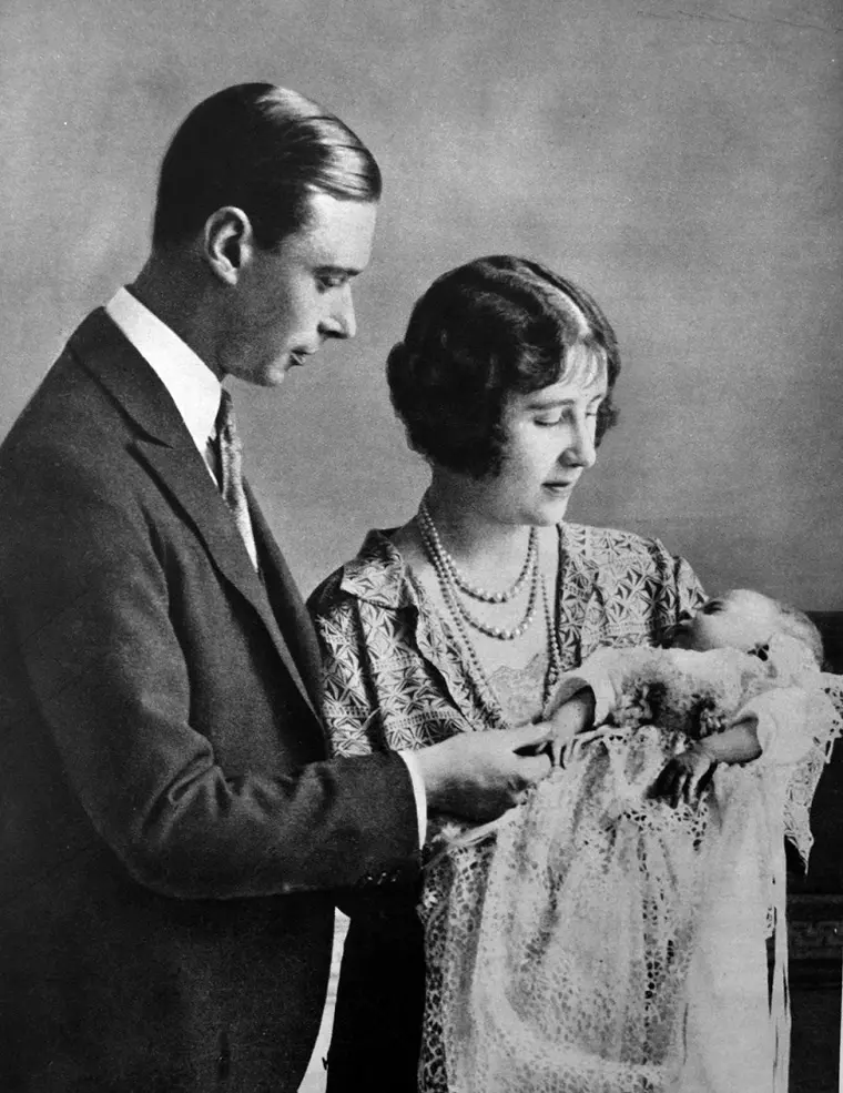 Portert de familie cu regina elisabeta a II-a pe vremea cand era bebelus, alături de părinții ei, regele george al VI-lea și Elisabeta regina mama, care o tinea in brate.