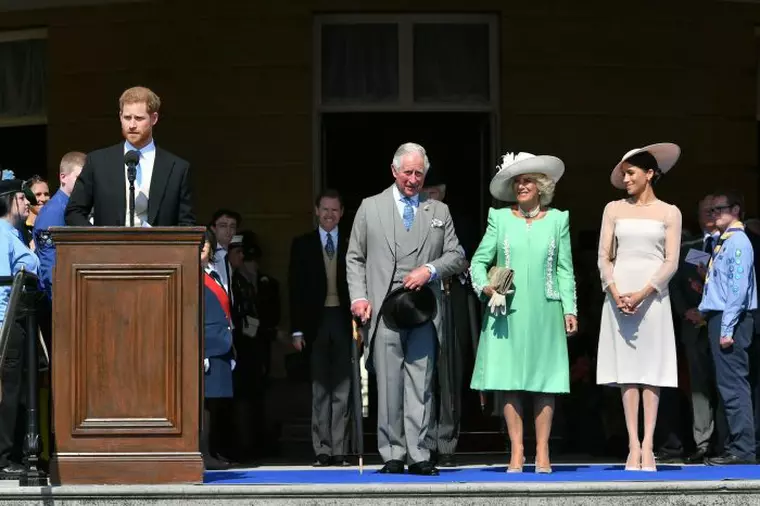 Meghan Markle, alături de socrii ei, Prințul Charles și Camilla, Ducesa de Cornwall, în timp ce Prințul Harry ține un discurs la tribună, de ziua tatălui său.