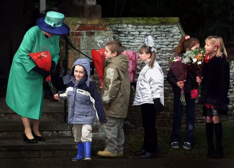 De Crăciun, Elisabeta a II-a primind daruri și felicitări de la copii, la biserica de la Sandringham.