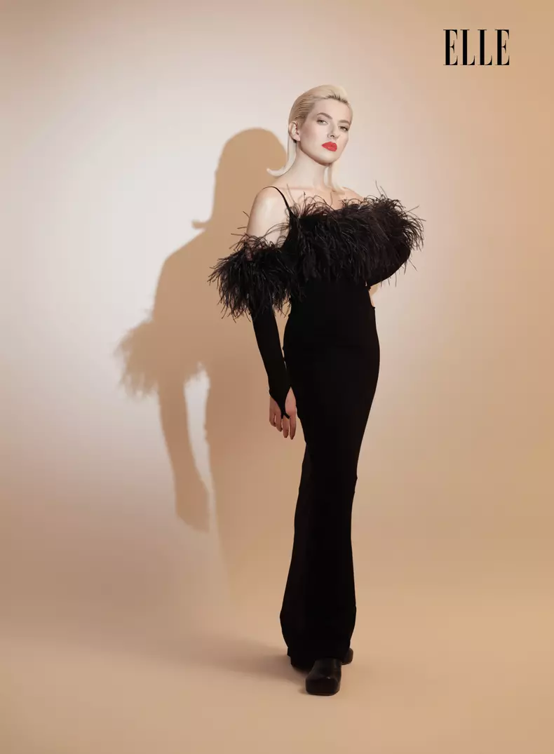 Rochie din jerse cu aplicații de pene de struț, Seen Users; cizme din piele, Bottega Veneta.