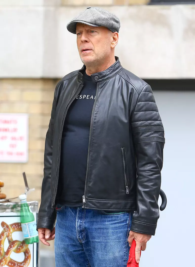 Bruce Willis se promène sur Prince Street à Soho, il porte une casquette grise et un parapluie rouge