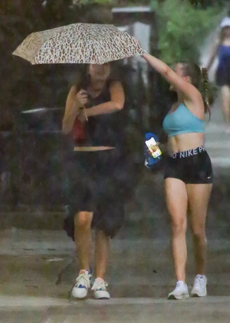 Suri Cruise Braves Big Apple Downpour with a Friend