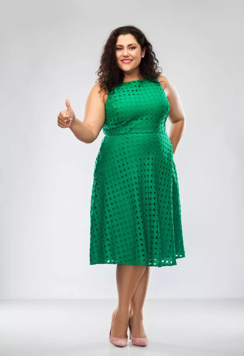 happy woman in green dress showing thumbs up