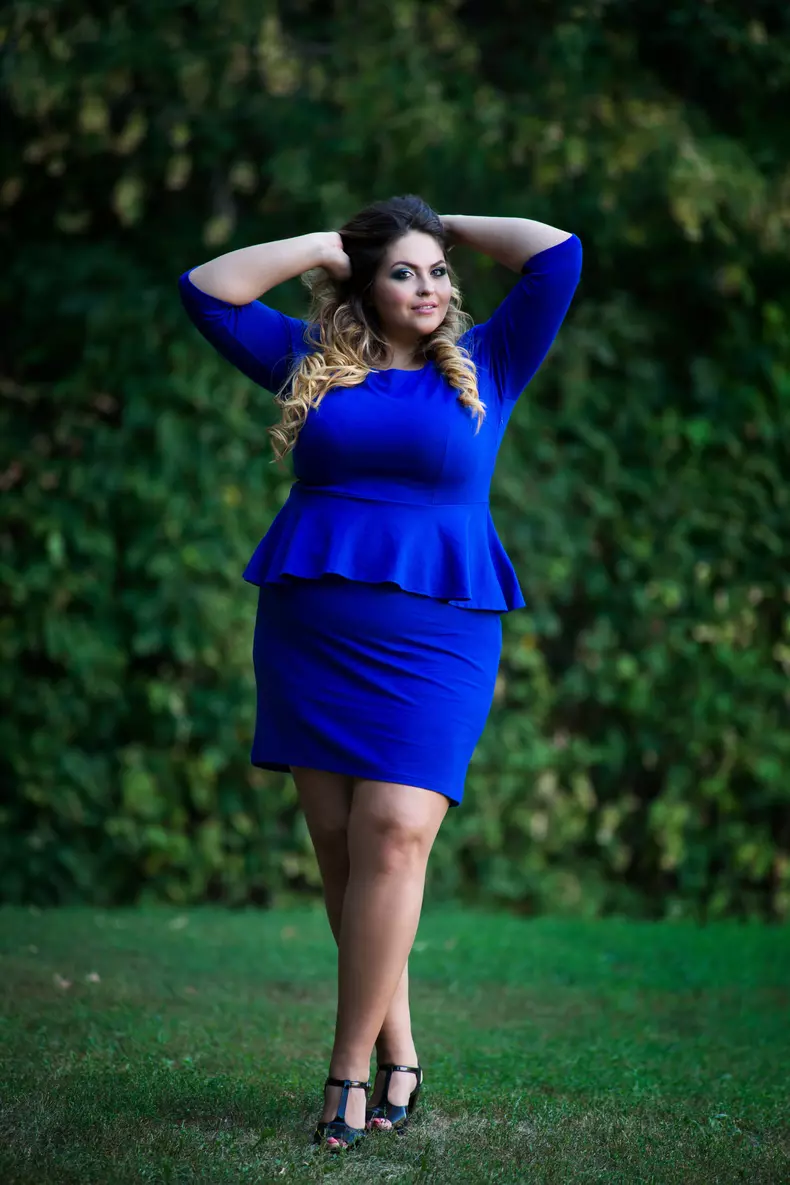 Young beautiful caucasian plus size fashion model in blue dress outdoors, xxl woman on nature