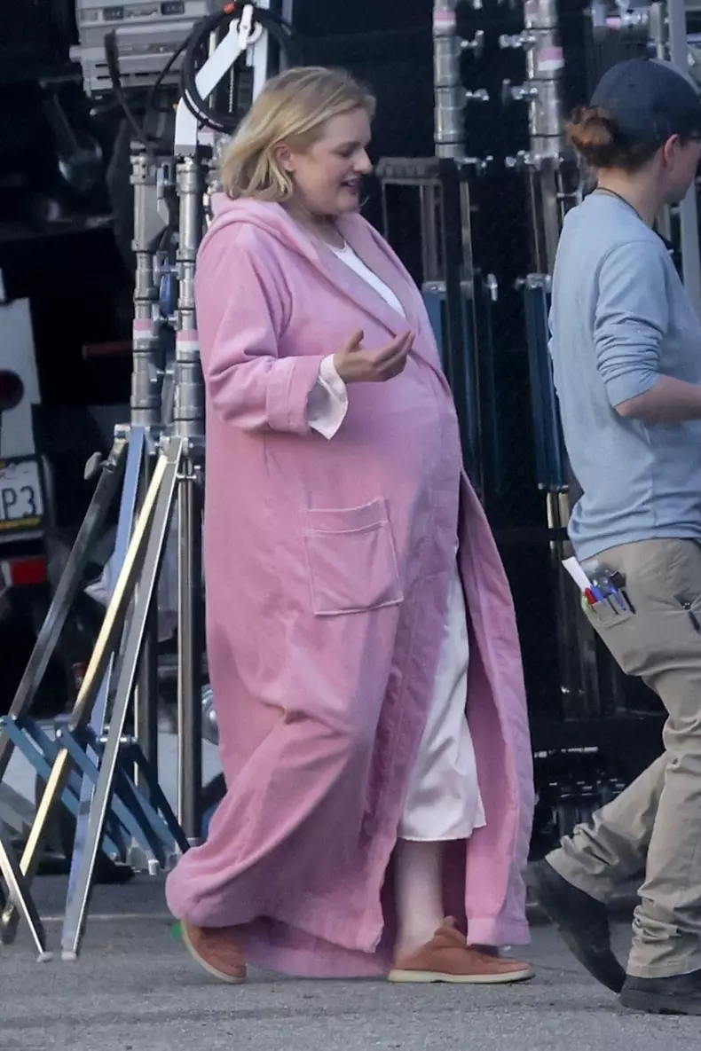 *PREMIUM-EXCLUSIVE* Elisabeth Moss sports a bump under her pink robe as she puts her feet up while on set with director Max Minghella
