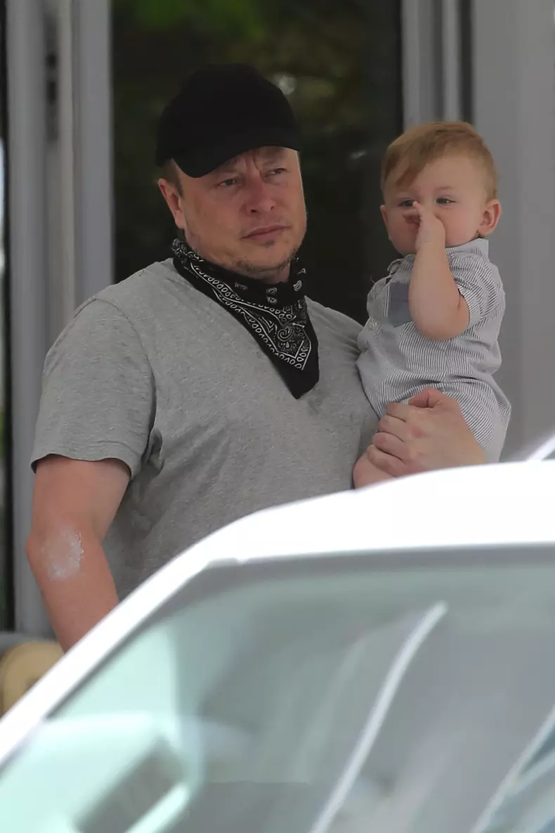 PREMIUM EXCLUSIVE:  Elon Musk carries his son "X" as he leaves his hotel with girlfriend Grimes in Miami