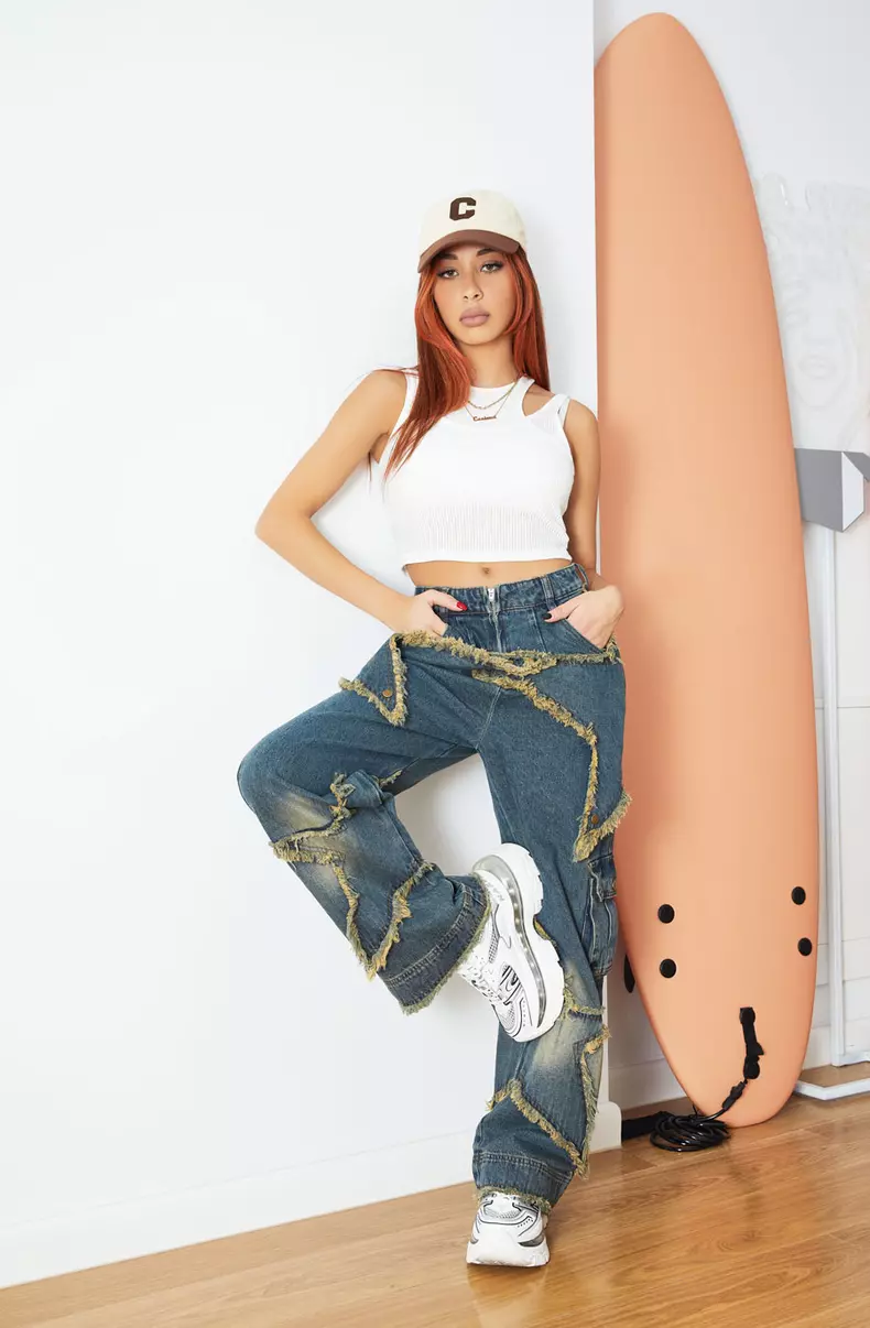 Cesima poartă crop top alb dublu Oysho, jeanși Aelfric Eden și pantofi sport Naked Wolfe.