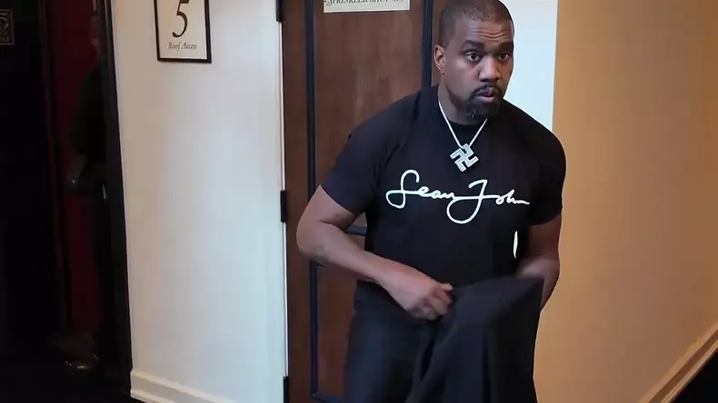 Kanye West wears a black KKK-inspired robe and hood with a swastika necklace and a Sean Jean t-shirt during an interview with DJ Akademiks