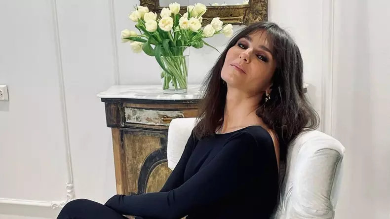 dana-budeanu-sta-pe-un-fotoliu-alb