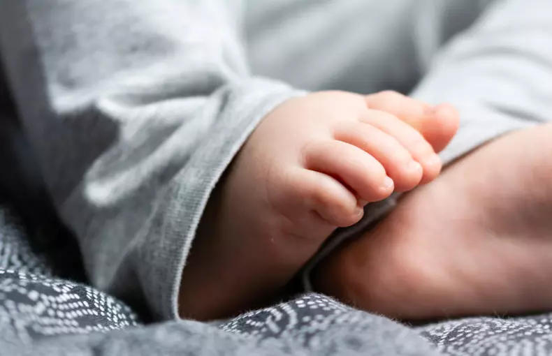 Close up on a Baby Feet on a Bed with a Black Sheet