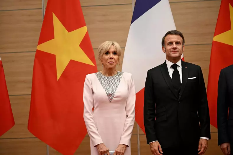 Le président français Emmanuel Macron et sa femme Brigitte Macron, aux côtés de son homologue vietnamien Luong Cuong avec sa femme Nguyen Thi Minh Nguyet, lors d'un dîner d'État au Centre international des congrès de Hanoï