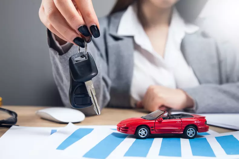 woman holding key with car model