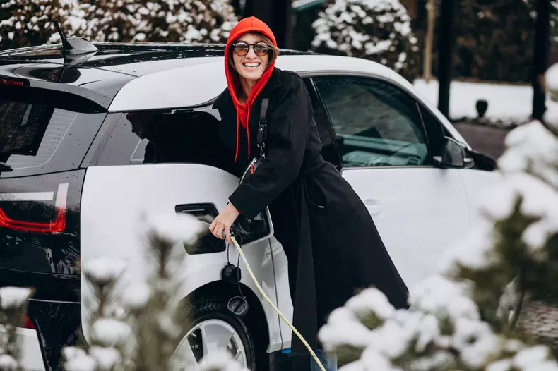 Woman charging electro car by her house